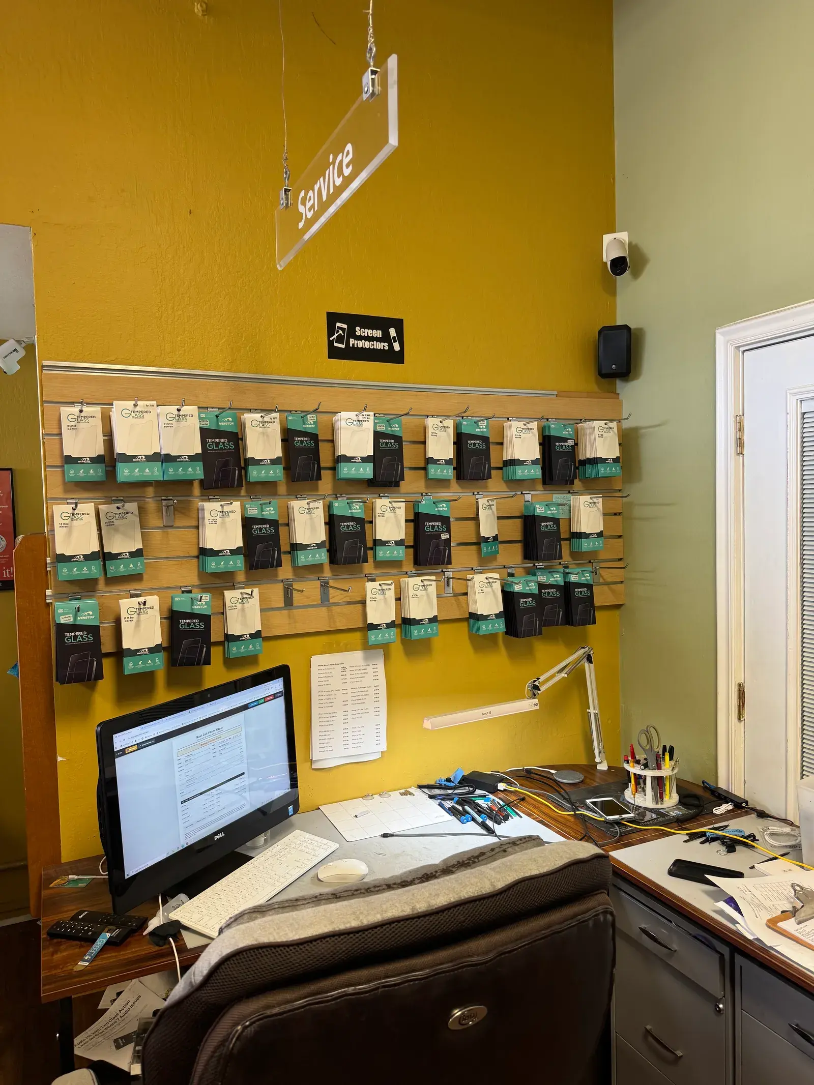 Screens and parts stocked on the shop wall